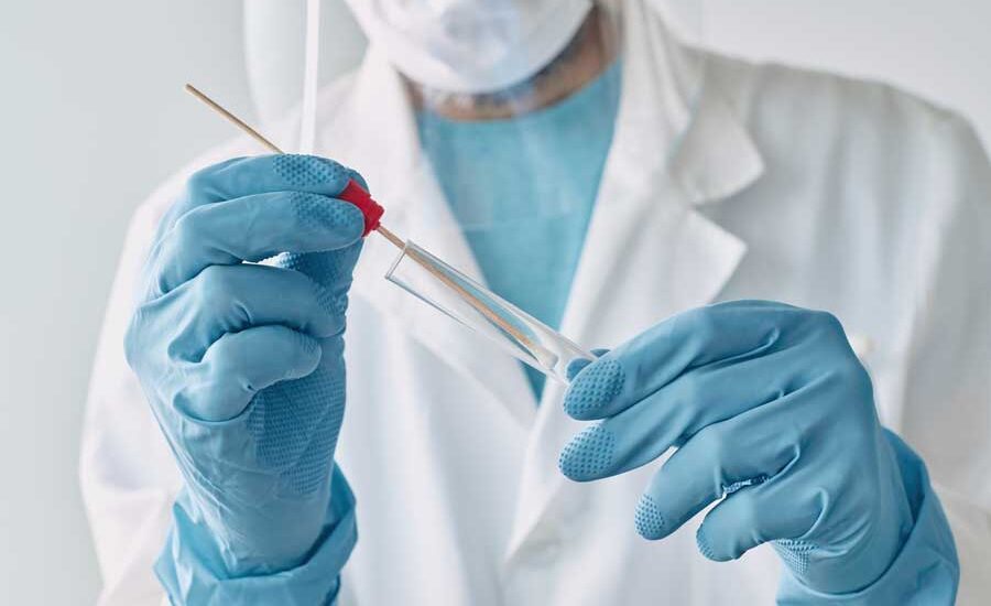 Doctor putting a q-tip in a test tub after an oral swab.